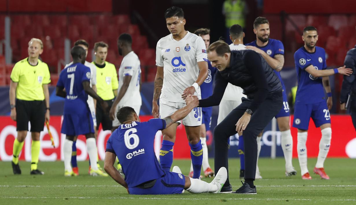Manajer tim Chelsea, Thomas Tuchel membantu bek Thiago Silva berdiri usai berakhirnya laga leg kedua perempatfinal Liga Champions 2020/2021 melawan Porto di Ramon Sanchez Pizjuan Stadium, Sevilla, Selasa (13/4/2021). Chelsea kalah 0-1 dari Porto. (AP/Angel Fernandez)