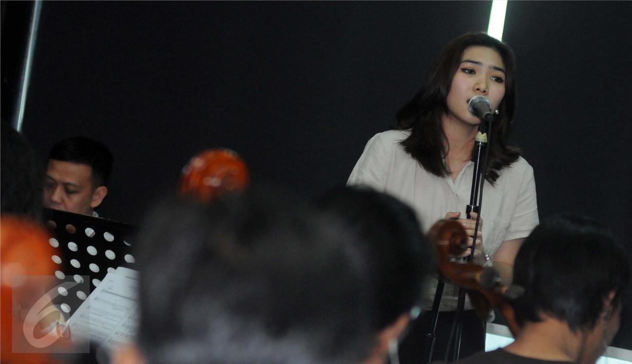 Isyana Sarasvati saat latihan bersama personel Dekat, Mohammed Kamga dan Erwin Gutawa Orchestra di kawasan Cilandak, Jakarta, Minggu (21/8). Isyana dan Kamga akan duet pada malam puncak HUT SCTV ke-26. (Liputan6.com/Helmi Afandi)