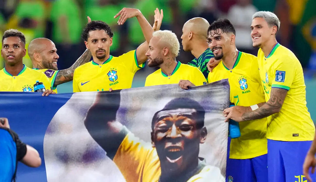 Para pemain Brasil membentangkan spanduk dukungan untuk Pele yang sedang sakit pada akhir pertandingan sepak bola babak 16 besar Piala Dunia 2022 antara Brasil dan Korea Selatan di Stadium 974, Doha, Qatar, 5 Desember 2022. (AP Photo/Andre Penner)