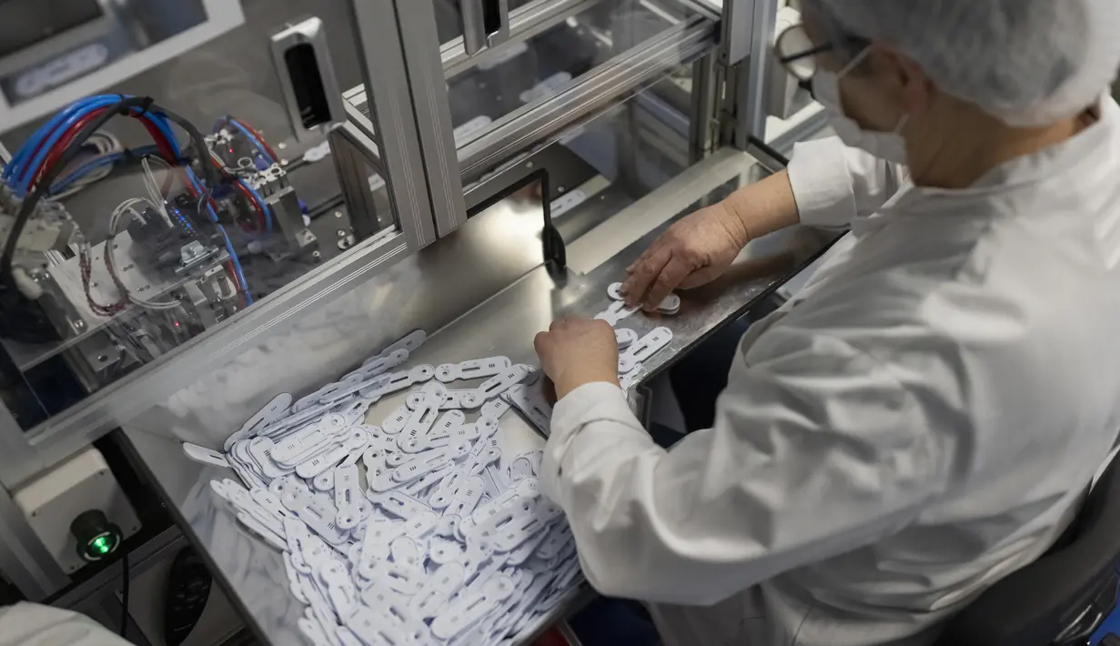 Karyawan bekerja di jalur perakitan NG Biotech, start-up pembuat berbagai tes medis, termasuk kit COVID-19, di Guipry, Prancis, 7 Januari 2022. Prancis memecahkan rekor infeksi harian tertinggi di Eropa membuat produsen bekerja keras memenuhi permintaan besar untuk tes. (AP Photo/Jeremias Gonzalez)