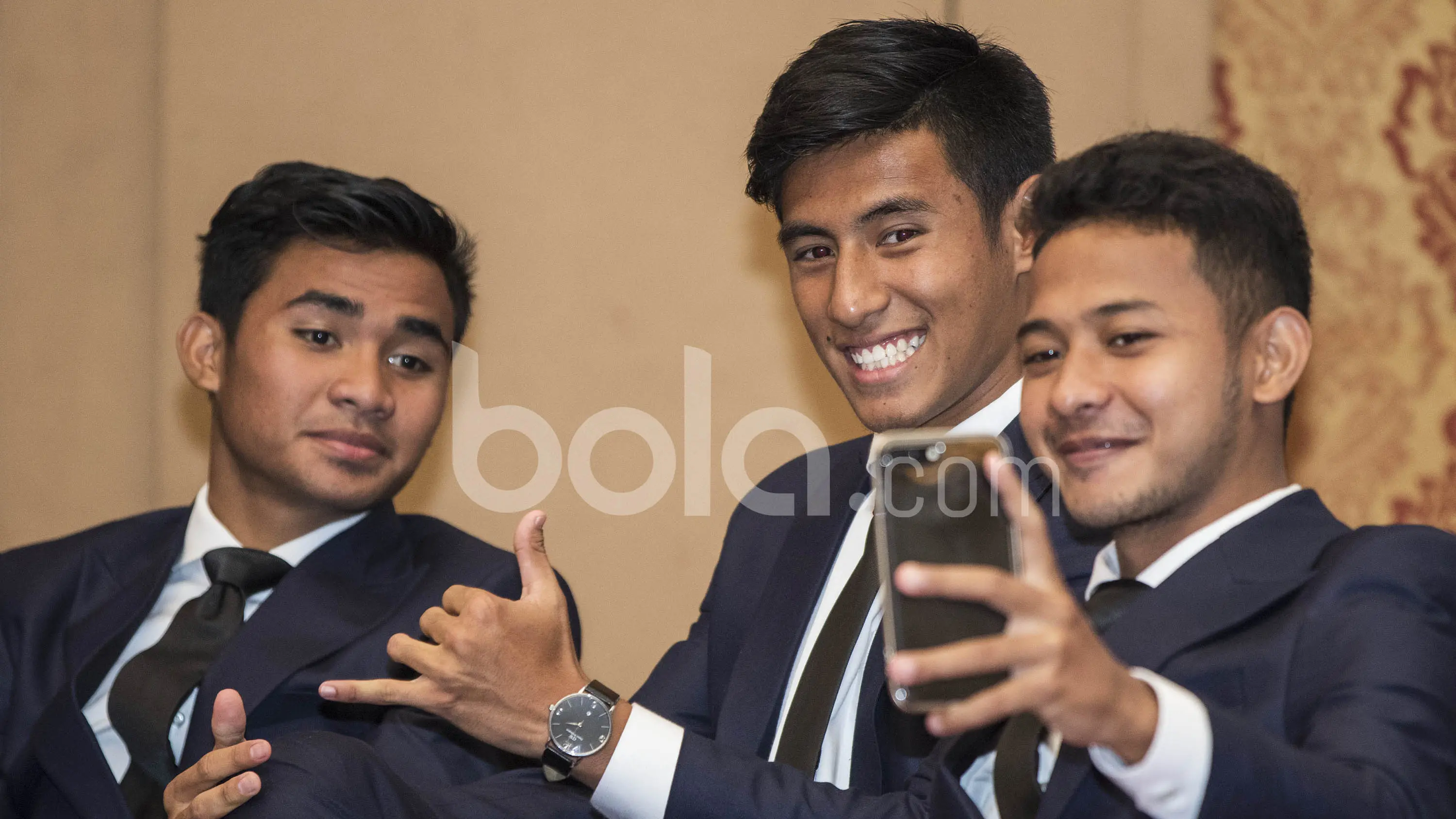Pemain Timnas Indonesia U-22, Gian Zola, Hanif Sjahbandi (tengah) dan Asnawi Mangkualam (kiri), melakukan selfie. Dengan memakai pakaian ini Timnas U-22 diharapkan bisa tampil lebih elegan membawa citra bangsa. (Bola.com/Vitalis Yogi Trisna)