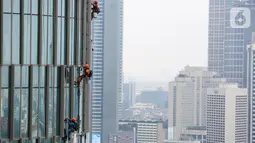 Pekerja membersihkan kaca gedung bertingkat di Jakarta, Jumat (26/02/2021). Berdasarkan data BP Jamsostek kasus kecelakaan kerja di Indonesia menurun 1,46 persen dengan catatan pada tahun 2020 mencapai 153.044 kasus dibandingkan 2019 sebanyak 155.327 kasus. (Liputan6.com/Fery Pradolo)