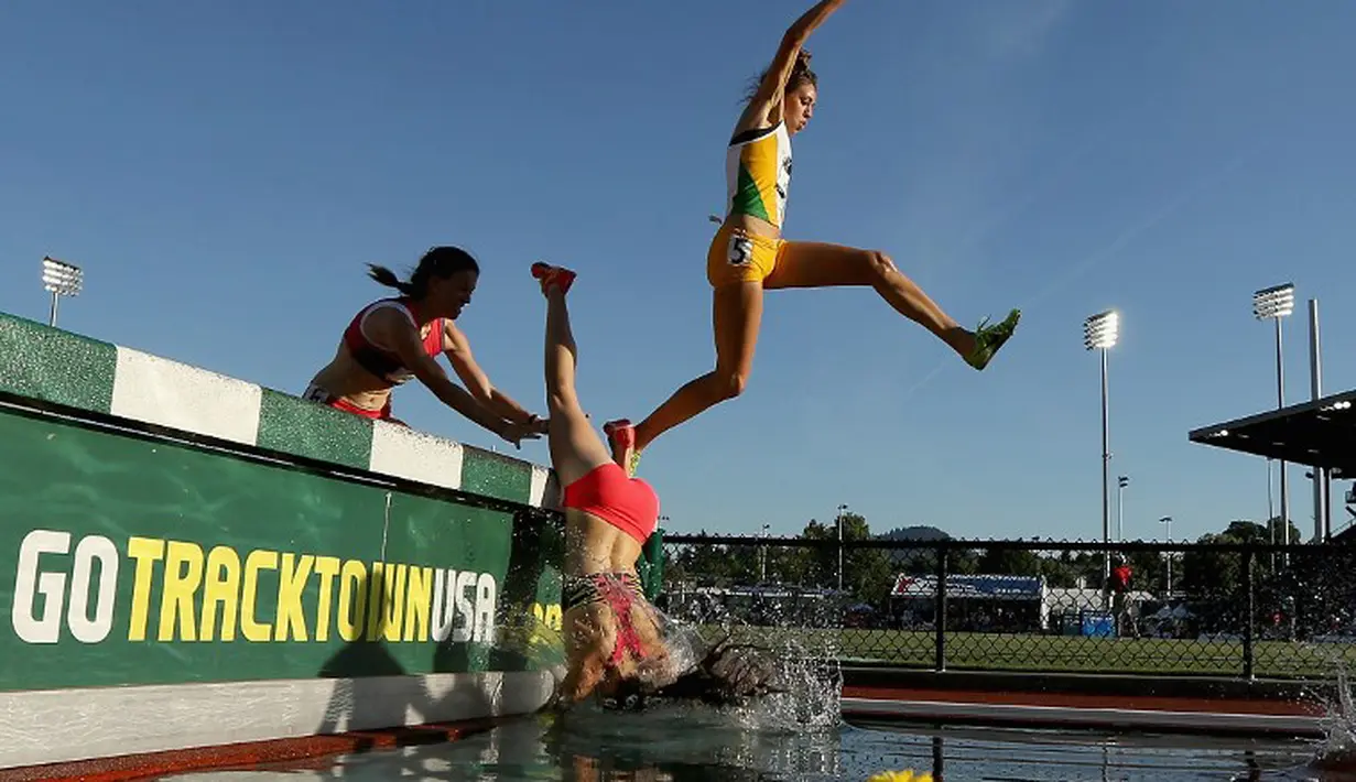 Seorang pelari putri terjatuh ke dalam air saat berlomba di nomor lari halang rintang 3000m dalam kejuaraan atletik AS Terbuka 2015 di Hayward Field, Oregon, AS. (25/6). (Andy Lyons/Getty Images/AFP)