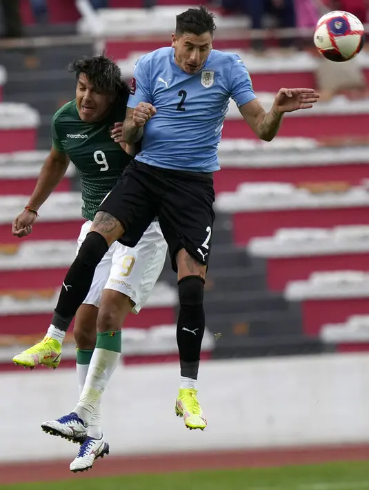 Pemain Bolivia Marcelo Martins (kiri) dan pemain Uruguay Jose Gimenez melakukan sundulan pada pertandingan kualifikasi Piala Dunia 2022 di Stadion Hernando Siles, La Paz, Bolivia, 16 November 2021. Bolivia menang 3-0. (AP Photo/Juan Karita)