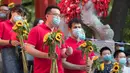 Para guru yang memegang bunga matahari menunggu para peserta di luar lokasi ujian masuk perguruan tinggi di Kota Harbin, Provinsi Heilongjiang, China, pada 8 Juli 2020. Ujian masuk perguruan tinggi nasional telah selesai digelar di beberapa bagian wilayah China pada Rabu (8/7). (Xinhua/Zhang Tao)
