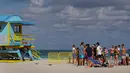 Orang-orang bersenang-senang di pantai di Miami, Florida pada Selasa (16/3/2021). Mahasiswa telah tiba di daerah Florida Selatan untuk liburan musim semi tahunan. Para pejabat kota prihatin dengan kerumunan liburan musim semi saat pandemi COVID-19 terus berlanjut. (Joe Raedle/Getty Images/AFP)