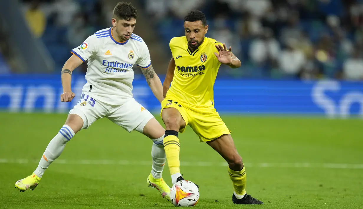 Gelandang Real Madrid Federico Valverde berebut bola dengan gelandang Villarreal Francis Coquelin pada jornada ketujuh La Liga Spanyol di Santiago Bernabeu, Minggu (26/9/2021) dini hari WIB. Real Madrid hanya mampu bermain imbang tanpa gol kala menjamu Villarreal. (AP Photo/Manu Fernandez)