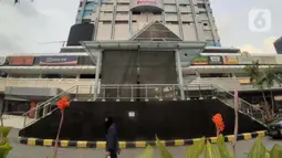 Warga berjalan di depan Gedung Sarinah, Jalan MH Thamrin, Jakarta, Selasa (12/5/2020). Pusat perbelanjaan pertama di Indonesia ini didirikan pada 17 Agustus 1962, dan resmi dibuka 15 Agustus 1966. Bangunan ini memiliki ketinggian sekitar 74 meter dengan 15 lantai. (Liputan6.com/Helmi Fithriansyah)