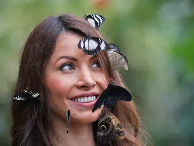 Wajah seorang wanita bernama Jessie dihiasi kupu-kupu saat berpose dalam sesi foto di Wisley Gardens, Inggris (12/1). Lebih dari 50 spesies kupu-kupu eksotis terbang bebas ditempat ini. (AP Photo / Frank Augstein)