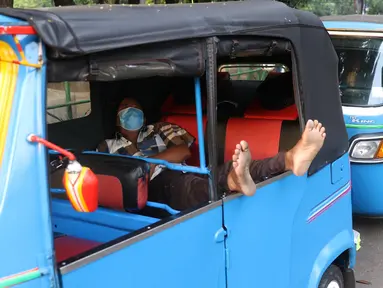 Pengemudi bajaj tengah beristirahat saat menunggu penumpang di kawasan Taman Puring , Jakarta, Minggu (11/7/2021). Dampak dari PPKM darurat membuat penghasilan para pengemudi bajaj menurun drastis hingga 70 pesen. (Liputan6.com/Angga Yuniar)