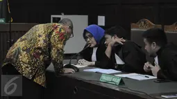 Terdakwa perantara suap Panitera PN Jakarta Pusat, Doddy Aryanto Supeno berdiskusi dengan kuasa hukumnya sebelum mendengarkan pembacaan putusan di Pengadilan Tipikor Jakarta, Rabu (14/9). Doddy divonis 4 tahun penjara. (Liputan6.com/Faizal Fanani)