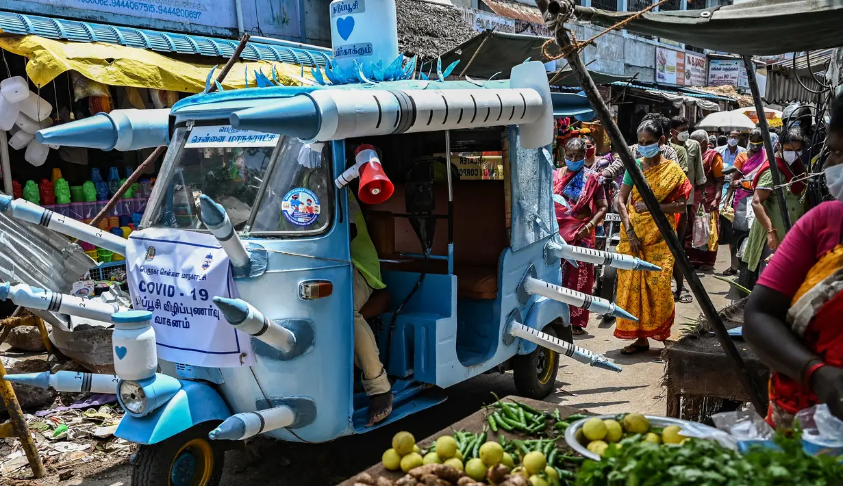 Seorang pekerja kota mengendarai bajaj yang dihiasi dengan jarum suntik tiruan di jalanan di Chennai, India pada Sabtu (3/6/2021). Seorang seniman di Chennai menghias bajaj tersebut untuk meningkatkan kesadaran orang-orang tentang pentingnya vaksinasi Covid-19. (Arun SANKAR/AFP)