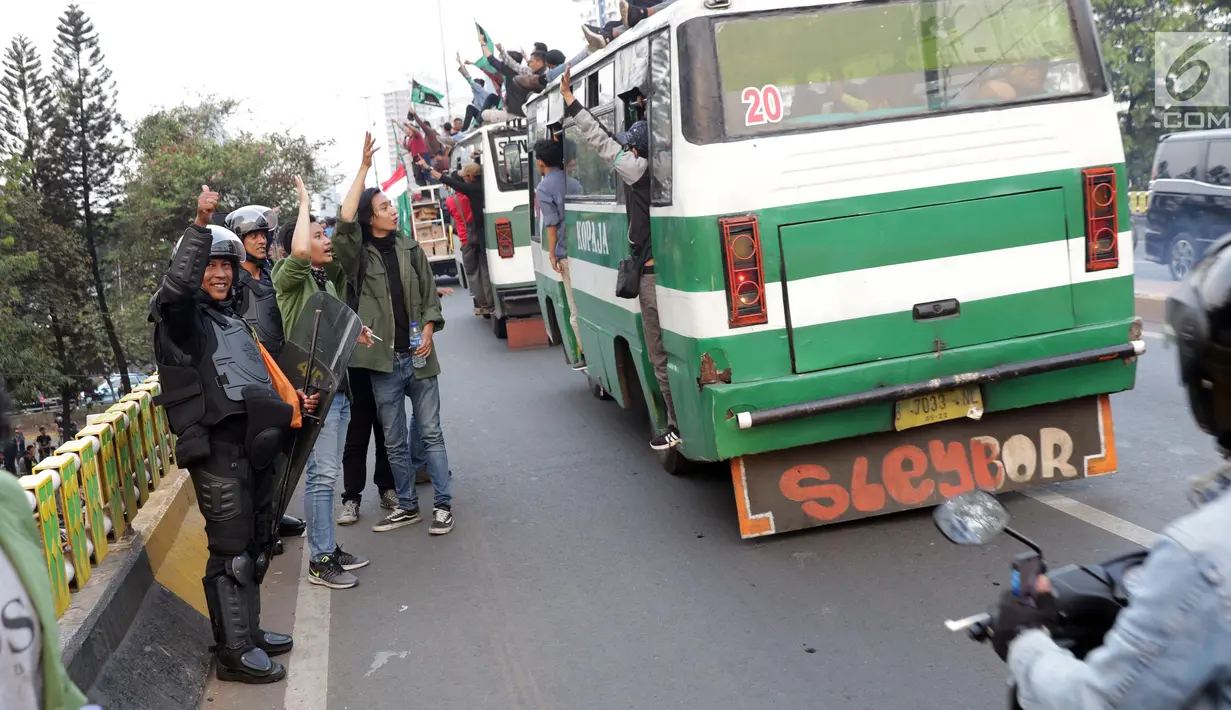 Personel Brimob melambaikan tangan kepada rombongan mahasiswa yang akan kembali usai berunjuk rasa di sekitar Jembatan Layang Gerbang Pemuda, Jakarta, Selasa (1/10/2019). Mahasiswa dari berbagai perguruan tinggi kembali berunjuk rasa menolak beberapa RUU. (Liputan6.com/Helmi Fithriansyah)