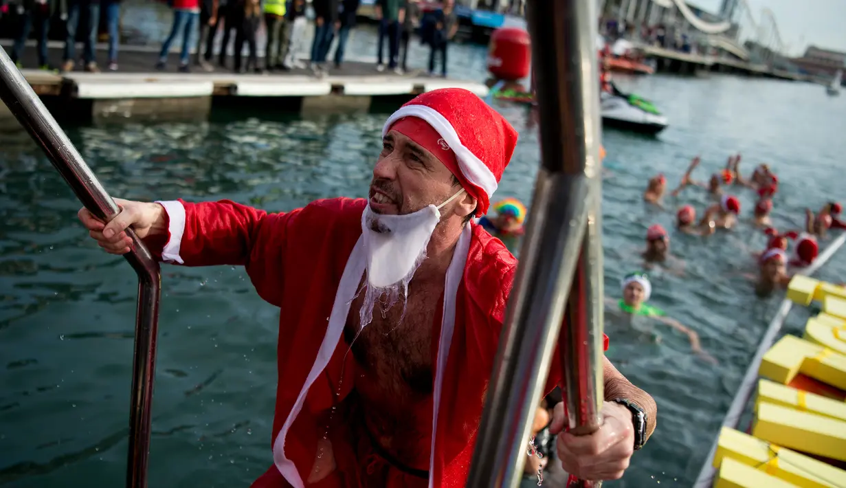 Seorang peserta dalam kostum sinterklas seusai mengikuti  kompetisi renang Copa Nadal di Port Vell Barcelona, Selasa (25/12). Lebih dari 300 peserta menempuh jarak sejauh 200 meter pada lomba renang tradisional tersebut. (Josep LAGO / AFP)