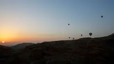 Sejumlah balon udara yang membawa wisatawan terbang saat matahari terbit di atas kota Luxor, Kairo, Mesir (13/12). Luxor adalah sebuah kota modern yang terletak di kedua tepi timur dan barat Sungai Nil di Mesir bagian utara. (Reuters/Amr Abdallah Dalsh)
