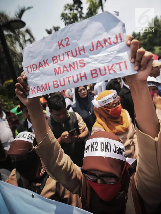 Pegawai honorer DKI Jakarta mengangkat kertas bertuliskan aspirasi saat demo di Balai Kota, Jakarta, Rabu (26/9). Mereka menuntut Gubernur DKI Jakarta Anies Baswedan mengangkat mereka menjadi PNS. (Liputan6.com/Faizal Fanani)
