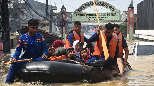 Tim penyelamat mengevakuasi warga yang rumahnya terendam banjir di Perumahan Pondok Gede Permai di Bekasi, Jawa Barat pada 4 Maret 2025. (REZAS/AFP)