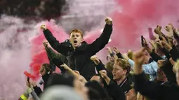 Para fans Manchester United menyalakan flare saat merayakan kemenangan 2-1 timnya atas Sheffield United setelah berakhirnya laga pekan ke-9 Liga Inggris 2023/2024 di Bramall Lane, Sheffield, Minggu (22/10/2023) dini hari WIB. (AP Photo/Jon Super)