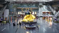 Sebuah gambar yang diambil pada 11 Januari 2021 menunjukkan penumpang berjalan di sekitar toko-toko di aula keberangkatan Hamad International Airport Qatar dekat Doha. (KARIM JAAFAR / AFP)