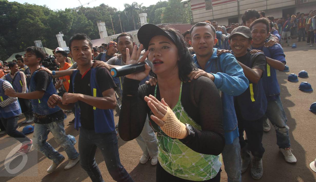 Pekerja renovasi Stadion Utama GBK mengikuti instruktur senam sebelum beraktivitas di kawasan Senayan, Jakarta, Jumat (17/3). Senam dilakukan untuk menjaga kebugaran pekerja yang rutin diadakan setiap Jumat pagi. (Liputan6.com/Immanuel Antonius)