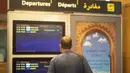 Pelancong memeriksa jadwal penerbangan yang dibatalkan dan berangkat di terminal di bandara Rabat, Senin (29/11/2021). Maroko menangguhkan semua penerbangan internasional mulai Senin tengah malam selama dua minggu karena kekhawatiran pada varian baru Covid-19 Omicron. (AP Photo/Mosa'ab Elshamy)