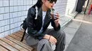 Gaya kasual keren Peggy Gou di foto ini. Ia mengenakan kaus putih, ditumpuknya dengan jaket kulit hitam, dan cargo pants abu-abu. [Foto: Instagram/peggygou_]
