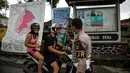 Turis asal Prancis, Anna Mangler (kiri) dan rekannya dari Jerman diberhentikan oleh polisi saat ingin memasuki area terlarang untuk melihat aliran lahar dingin Gunung Agung di Karangasem, Bali (29/11). (AFP Photo/Juni Kriswanto)