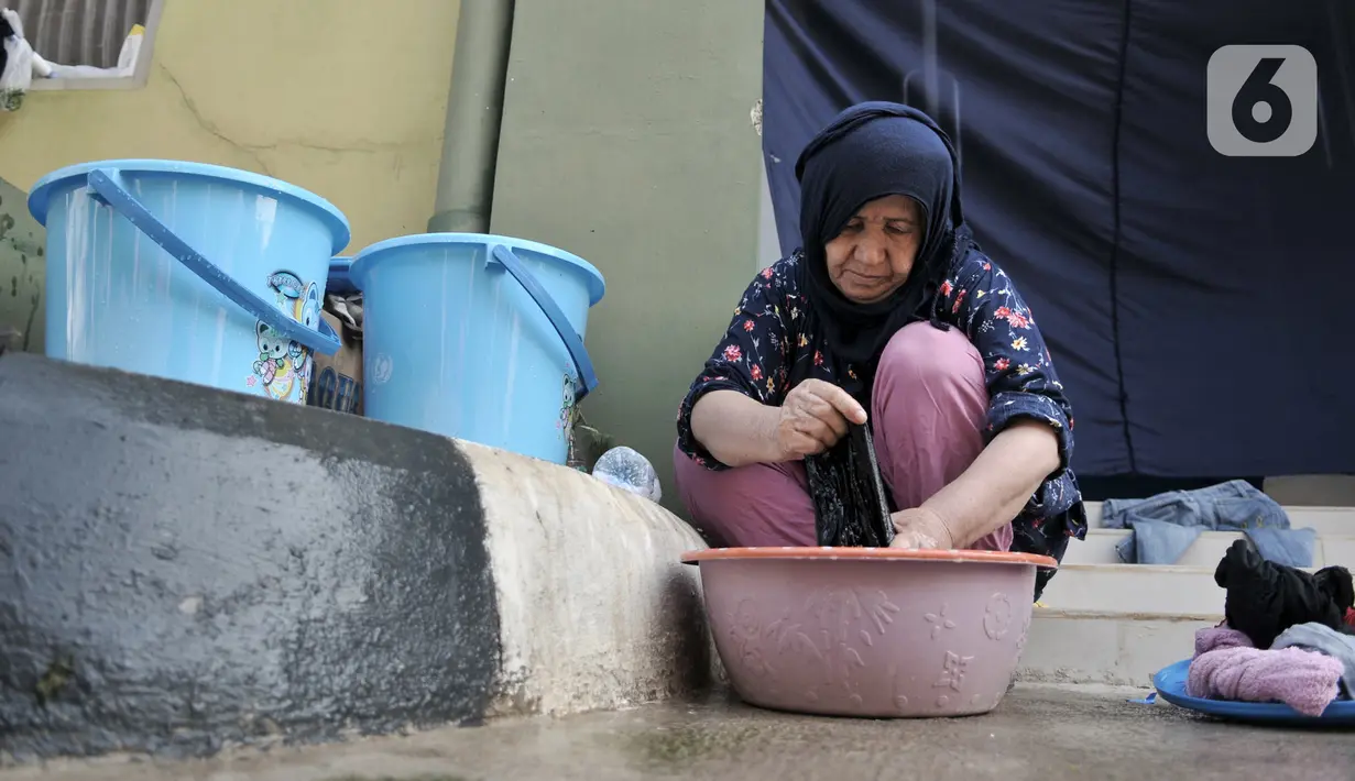Seorang imigran pencari suaka mencuci pakaian di penampungan sementara di Kalideres, Jakarta, Rabu (18/12/2019). Para imigran menjalani hidup seadanya di penampungan sementara sejak diungsikan oleh Pemprov DKI Jakarta pada Juli 2019. (merdeka.com/Iqbal Nugroho)