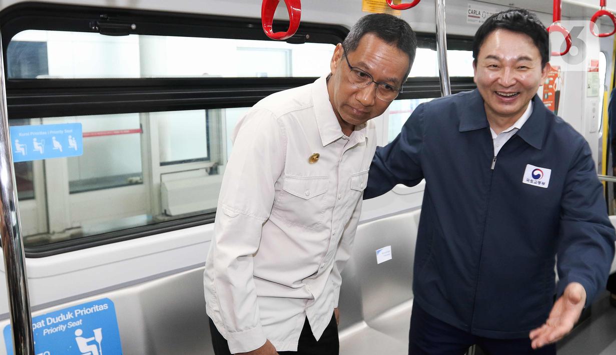 Penjabat (Pj) Gubernur DKI Jakarta Heru Budi Hartono  bersama Menteri Agraria, Infrastruktur dan Transportasi Korea Selatan Won Hee-ryong menaiki Light Rail Transit (LRT) di Jakarta, Jumat (17/3/2023). (Liputan6.com/Herman Zakharia)