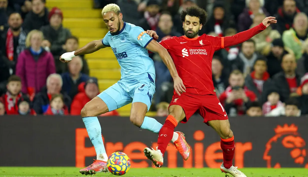 Pemain Newcastle United Joelinton (kiri) berduel memperebutkan bola dengan pemain Liverpool Mohamed Salah pada pertandingan sepak bola Liga Inggris di Stadion Anfield, Liverpool, Inggris, 16 Desember 2021. Liverpool menang 3-1. (AP Photo/Jon Super)