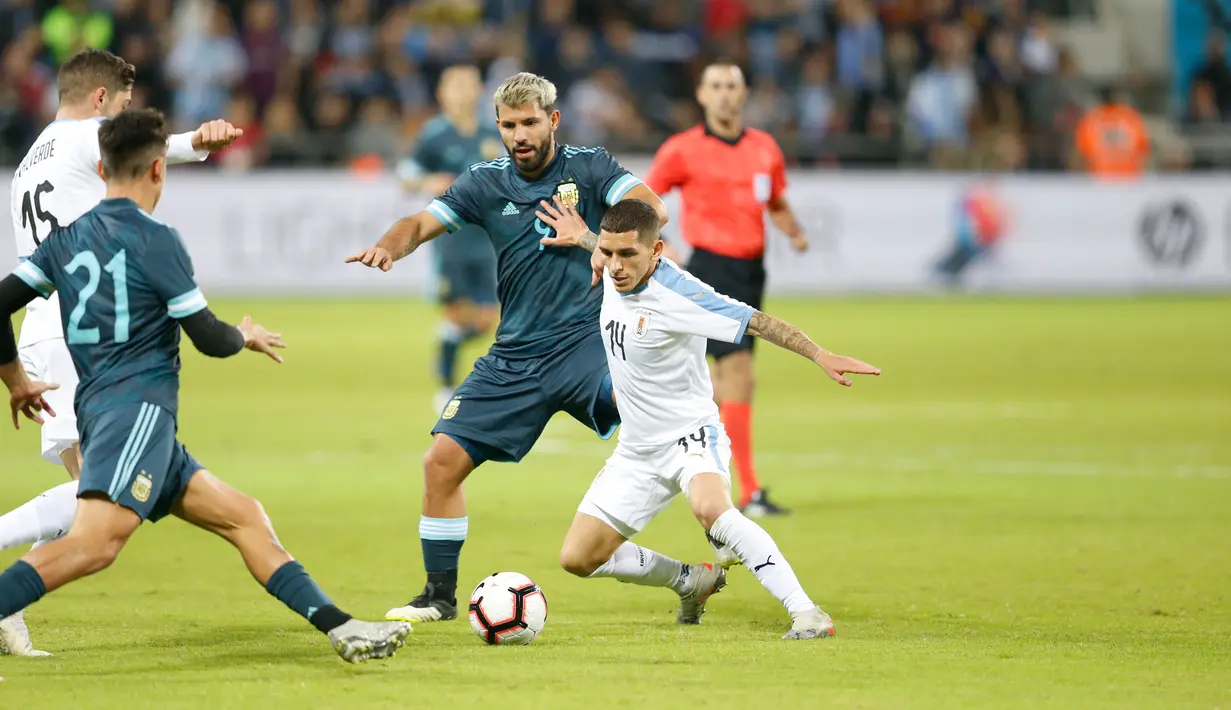 Pemain timnas Uruguay Luvcas Torreira berebut bola dengan striker timnas Argentina, Sergio Aguero dalam laga persahabatan di Stadion Bloomfield, Tel Aviv, Israel, Senin (18/11/2019). Skor berakhir 2-2, dengan penalti Lionel Messi menghindarkan timnas Argentina  dari kekalahan. (AP/Ariel Schalit)