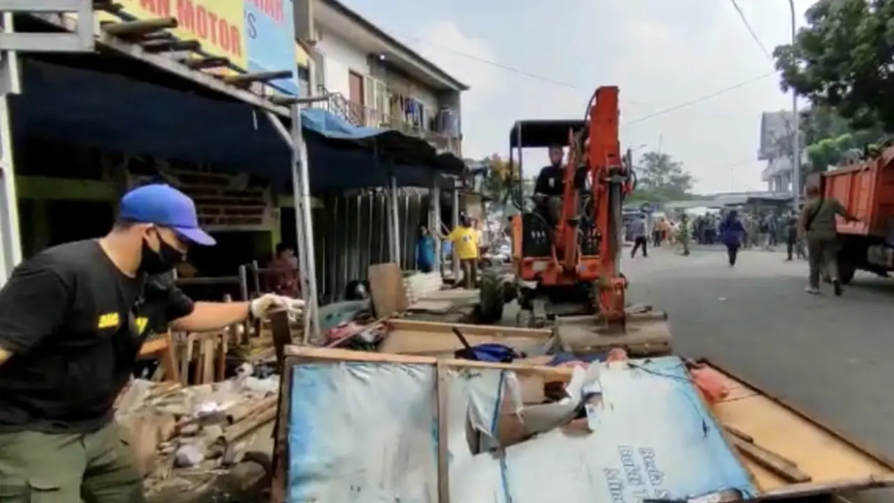 Satpol PP Kota Depok saat melakukan penertiban bangunan liar di jalan sejajar rel, Depok