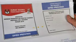 Petugas menunjukkan surat suara yang terkena bercak noda di Gedung Logistik KPU Kota Jakarta Pusat, Salemba, Jakarta, Selasa (5/3). Sebanyak 60 persen surat suara rusak akibat terpotong atau tidak simetris dan bercak noda. (merdeka.com/Iqbal Nugroho)