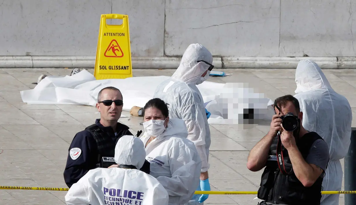 Petugas berjaga di dekat korban penyerangan di luar stasiun kereta api Saint Charles, di Marseille, Prancis Selatan, (1/10). Dua orang tewas dalam sebuah serangan pisau yang dilakukan seorang pria di stasiun tersebut. (AP Photo/Claude Paris)