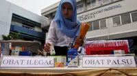 Petugas memperlihatkan sejumlah obat ilegal dan palsu sebelum dimusnahkan di halaman Kantor BPOM, Jakarta, Senin (26/5/14). (Liputan6.com/Johan Tallo)