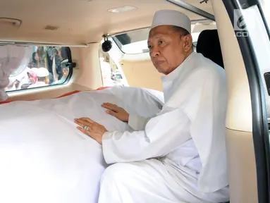 Wakil Presiden ke-9 RI, Hamzah Haz memegang peti jenazah istrinya, Asmaniah jelang diberangkatkan dari rumah duka di Jakarta, Selasa (12/9). Jenazah akan dimakamkan di pemakaman keluarga di Bogor, Jawa Barat. (Liputan6.com/Helmi Fithriansyah)