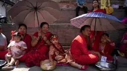 Anak-anak perempuan di bawah usia sembilan tahun berkumpul untuk mengikuti tradisi pemujaan. (AP Photo/Niranjan Shrestha)