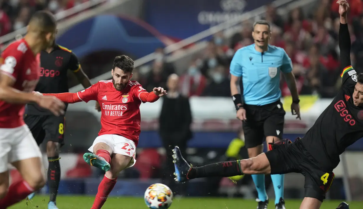 Gelandang Benfica, Rafa Silva melakukan tembakan dari kawalan pemain Ajax, Edson Alvarez pada pertandingan leg pertama babak 16 Liga Champions di Stadion Da Luz, Lisbon, Kamis (24/2/2022). Benfica bermain imbang atas Ajax 1-1.  (AP Photo/Armando Franca)