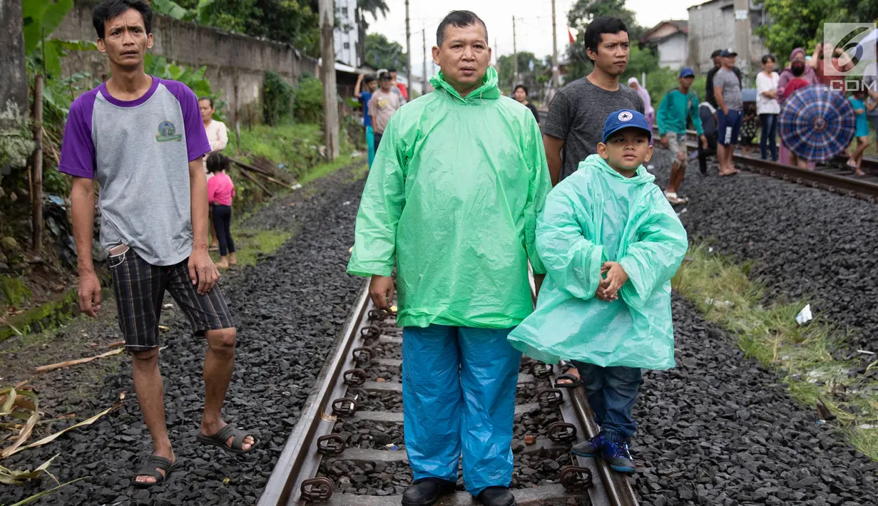 Warga melihat proses evakuasi KRL yang anjlok di kawasan Kebon Pedes, Bogor, Jawa Barat, Minggu (10/3). Kepala Daop I Jakarta Dadan Risdiansyah memastikan penanganan KRL yang anjlok selesai hari ini. (Liputan6.com/Immanuel Antonius)