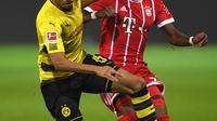 Gelandang Dortmund Jeremy Toljan berusaha membawa bola dari kawalan bek Bayern Munchen, David Alaba pada pertandingan Bundesliga Jerman di Dortmund, (4/11). Munchen menang telak 3-1 atas Dortmund. (AFP Photo/Patrik Stollarz)