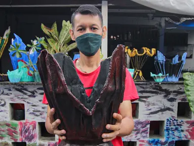 Seorang anak muda menunjukkan pot tanaman berbahan dasar kain bekas di  Cibodas, Kota Tangerang, Minggu (3/10/2021). Para pemuda di kawasan tersebut memanfaatkan PPKM untuk membuat Pot tanaman daur ulang yang dipasarkan mulai harga Rp. 30 ribu hingga Rp. 80 ribu. (Liputan6.com/Angga Yuniar)