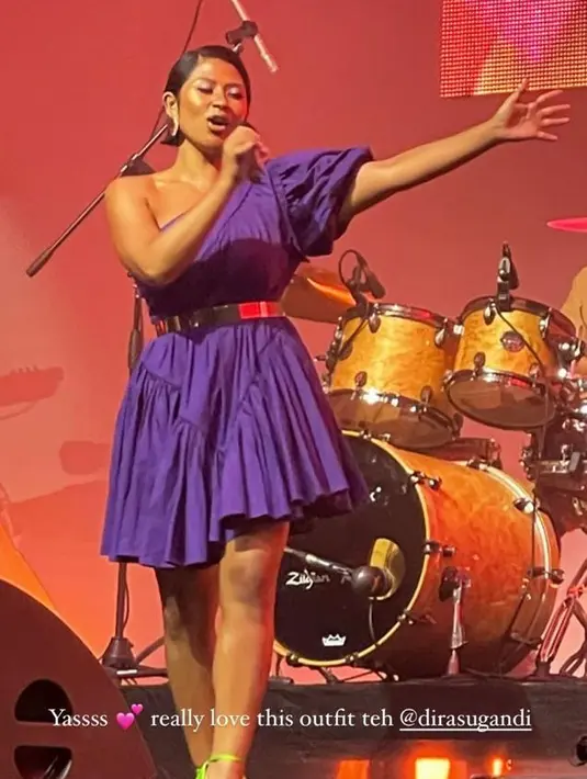 Dira Sugandi tampil nyentrik dengan one shoulder dress berwarna ungu dari The Story Of, dipadukan dengan strap heels warna hijau neon. [Foto: IG/beyondestiano].