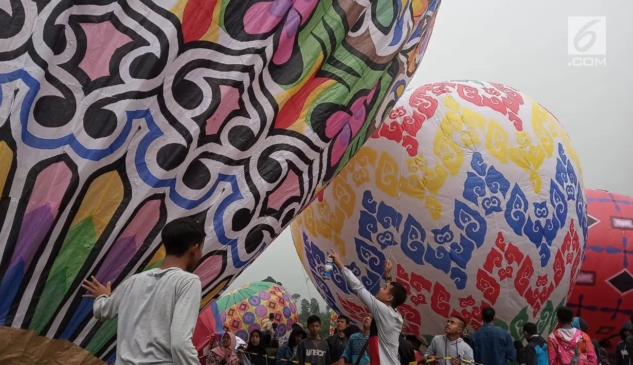 Peserta bersiap menaikan balon udara di Lapangan Pagerejo, Kertek, Kabupaten Wonosobo,  Sabtu (15/6/2019). Festival ini untuk memeriahkan syawalan dan wujud syukur warga yang hidup di lereng gunung sindoro dan sumbing. (Liputan6.com/Gholib)