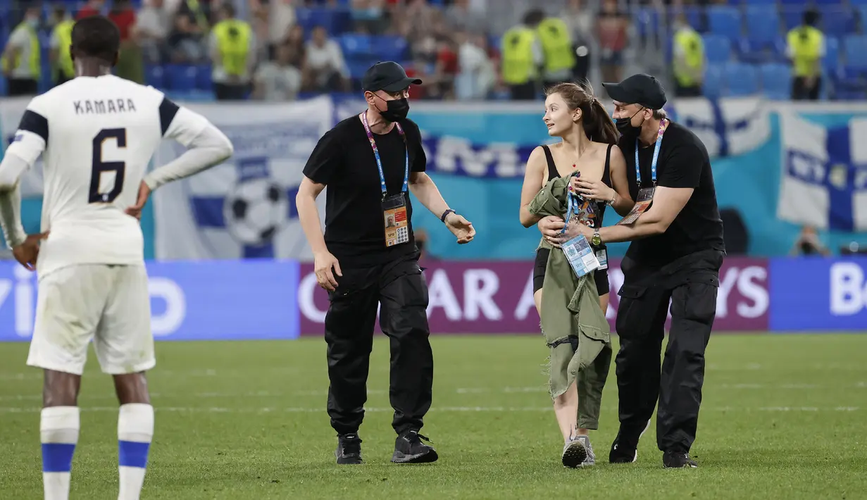 Menariknya, pakaian hitam wanita itu mempromosikan sesuatu yaitu WTF Coin. Menurut informasi yang dilansir oleh The Sun, WTF Coin adalah saingan Bitcoin, uang digital yang saat ini sedang naik daun. (Foto: AP/Pool/Anatoly Maltsev)