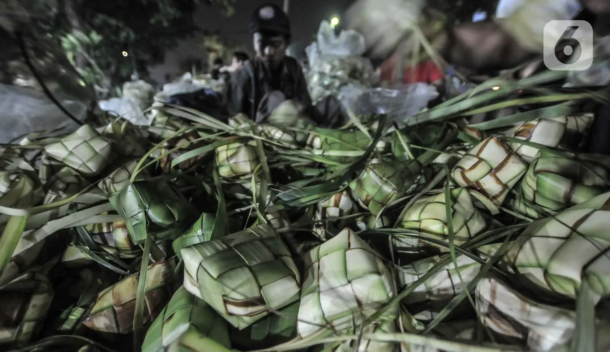 Aktivitas pedagang saat membuat bungkus atau tali ketupat di Pasar Klender, Jakarta Timur, Selasa (11/5/2021) malam. Menjelang Hari Raya Idul Fitri, Pasar Klender merupakan salah satu lokasi yang ramai dikunjungi warga untuk berburu ketupat, terutama saat malam hari. (merdeka.com/Iqbal S Nugroho)