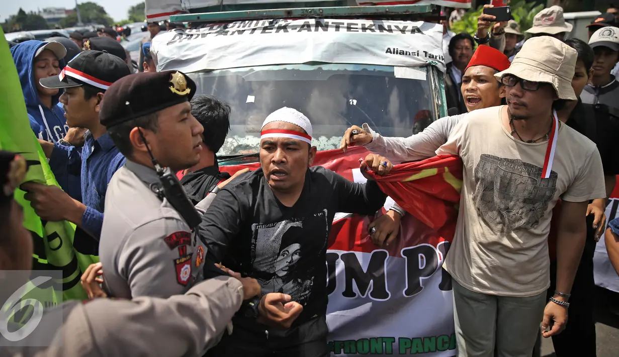 Aparat berusaha mengamankan massa aksi dari Front Pancasila saat berusaha masuk menuju Hotel Aryaduta, Jakarta, Senin (18/4). Mereka menolak Simposium PKI yang dapat dimanfaatkan menghidupkan kembali paham komunis. (Liputan6.com/Faizal Fanani)
