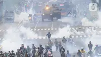 Petugas Brimob Polri menembakkan gas air mata untuk membubarkan massa usai terjadi lemparan batu di Jalan MH Thamrin, Jakarta, Selas (13/10/2020). Massa pengunjuk rasa yang menolak Omnibus Law akhirnya dibubarkan aparat. (merdeka.com/Arie Basuki)