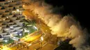 Sejumlah turis asik menonton ombak yang tinggi di pantai kota Vina del Mar, Chile,  (25/1).   Wisatawan sudah di himbau untuk menjauh dari bibir pantai karena ombak dan angin yang tinggi. (REUTERS / Rodrigo Garrido)