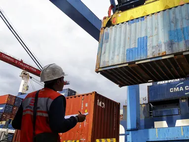 Pekeja memantau bongkar muat peti kemas di Pelabuhan Tanjung Priok, Jakarta, Selasa (19/3). Memasuki Era Baru Pelabuhan, IPC berkomitmen untuk mendukung program pemerintah guna menjadikan Indonesia sebagai poros maritim dunia. (Liputan6.com/Johan Tallo)