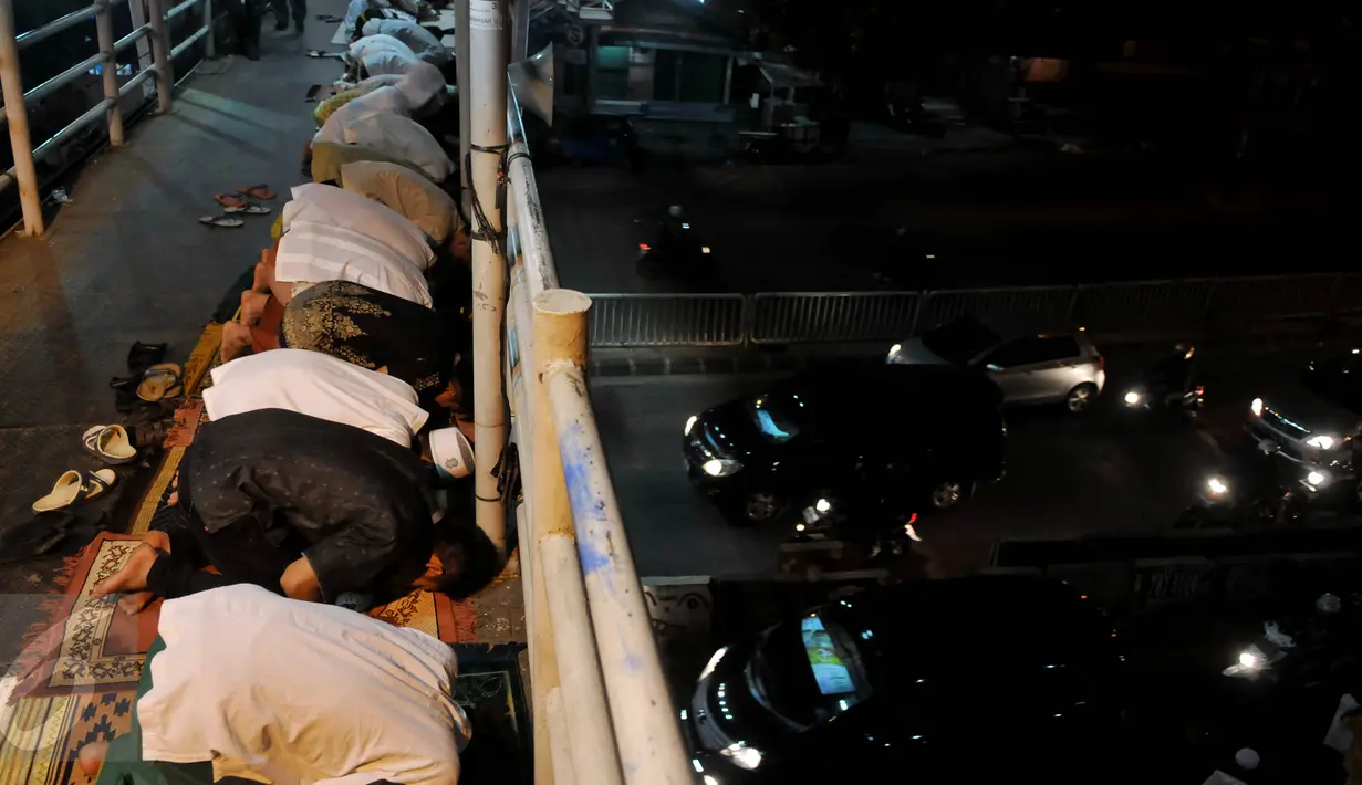 Suasana ibadah Salat Tarawih pertama di kawasan Pasar Gembrong, Jakarta, Rabu (17/6/2015). Terbatasnya jumlah daya tampung musholla membuat warga terpaksa salat di jembatan. (Liputan6.com/Johan Tallo)